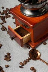 Wall Mural - selective focus. manual retro coffee bean mill. dark wood on a light gray background. with Cafe written in metal letters