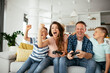 © JustLife - Husband and wife playing video games with joysticks in living room. Loving couple are playing video games with kids at home..