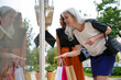 © Mangostar - Female friends holding shopping bags, standing at store outside, pointing and staring at windows. Low angle. Window shopping concept