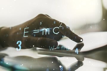 creative scientific formula hologram and hand working with a digital tablet on background, research 