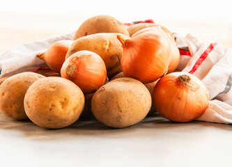 Wall Mural - golden onion and potaoes close up on kitchen table