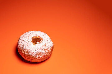 Wall Mural - Sufganiya for Jewish holiday Hanukkah on orange background with copy space.