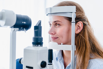 Wall Mural - Young woman patient undergoing ophthalmic vision check up : side view