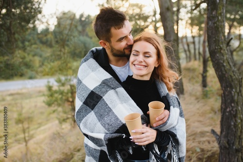 Fotomural young romantic couple in love in a gentle hug and warm themselves with a plaid,