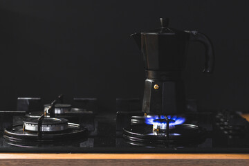 Black geyser retro coffee maker on the gas stove