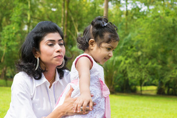 Wall Mural - Little girl learning how to walk with a parent