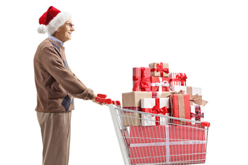 Wall Mural - Elderly man with a santa claus hat and a shopping cart with christmas presents