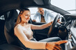 © fotofabrika - Joyful young couple looking around inside a new car they are going to buy in a car shop