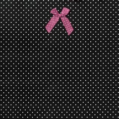 Wall Mural - Silk bow isolated on a black background with white dots