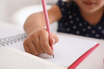 Canvas Print - Little girl doing homework at table, closeup