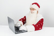 © Dzmitry - Santa Claus sits at his desk and works at the computer.
