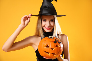 Canvas Print - Beautiful woman in witch costume with jack o'lantern on yellow background. Halloween party