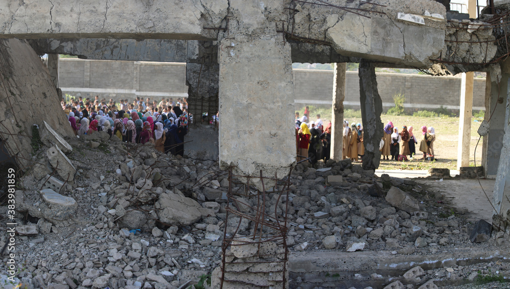 Yemeni children stand in line in the morning on the first day of school for the new year inside their school which destroyed by the war in Taiz city, Yemen