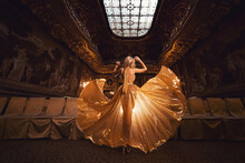 A Blonde Girl In A Luxury Gold Dress On The Background Of A Golden Interior