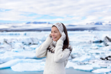 Portrait of multiracial woman on Iceland. Travel tourist in nature landscape by Jokulsarlon glacial lagoon on Iceland. Happy woman standing outdoors by destination landmark attraction.