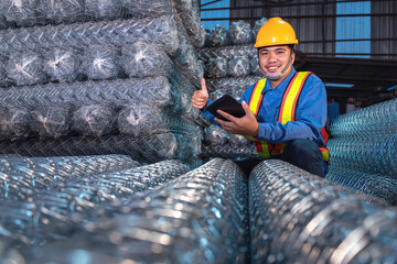 Cargo Inspection worker and give confidence Rolls of steel wire mesh for construction work in warehouse