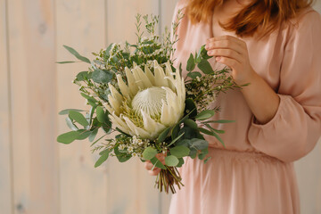 Wall Mural - woman holding a bouquet of flowers protea white
