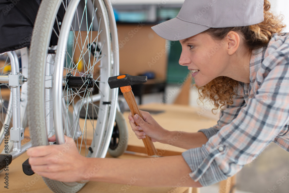 woman making an adjustment on a wheelchair - obrazy, fototapety, plakaty 