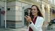 © stockbusters - Successful business woman having video conference by phone outdoors