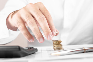 Businessman or accountant counting money and making stack of coins on financial data. Financing, Accounting and Banking Concept