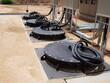 © kanin - Pumps in the sewage pumping station. Electrical wires and black metal cover of Submersible Pump on outdoor concrete tank. For drainage of municipal sewage or rainwater. Selective focus