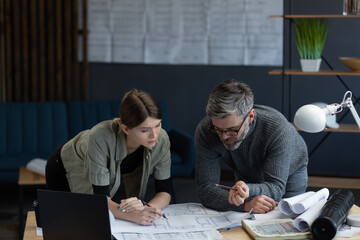 Engineer team working in office with blueprints and architect equipment, sketching, negotiating and planning construction project. Partners discussing at work. Business construction concept.