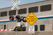High speed train warning sign at railroad crossing with motion blur of train in background. Concept of railroad crossing safety, danger and transportation industry