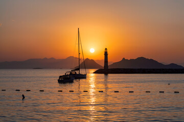 Wall Mural - Lighthouse at sunset in Mediterranean islands and marina with yachts in Bodrum, Turkey.