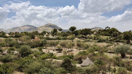 Ethiopian landscape of grass huts and mountains in the Borana region of Ethiopia.