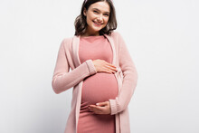 Joyful Pregnant Woman Touching Belly On White
