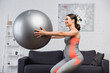 © LIGHTFIELD STUDIOS - pregnant woman doing squat with fitness ball in living room