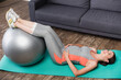 © LIGHTFIELD STUDIOS - brunette pregnant woman working out with fitness ball near sofa