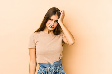 Young caucasian woman isolated en beige background tired and very sleepy keeping hand on head.