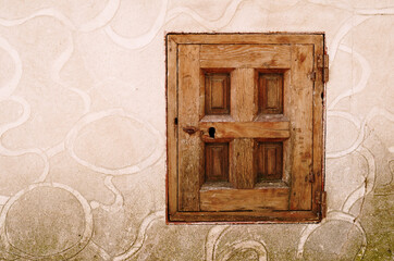 closed wooden village window on a brown stone background