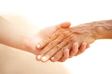 Elderly And Young Person Holding Hands Helping , Care And Respect.
