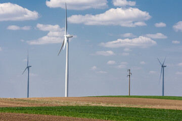 Wind turbines and agricultural field on a spring  day. Energy production, clean and renewable energy.