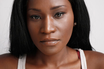 Wall Mural - Close-up portrait of black woman with serious face expression, posing on white background wall.