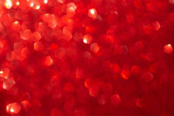 Red shiny blurred background with bokeh lights. Abstract festive background. Christmas, Valentine day concept.