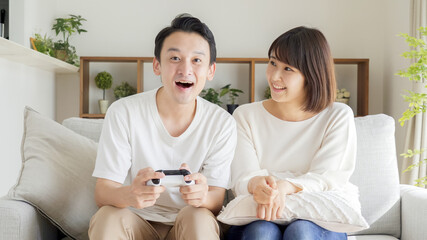 Wall Mural - リビングでテレビゲームをするカップル・夫婦