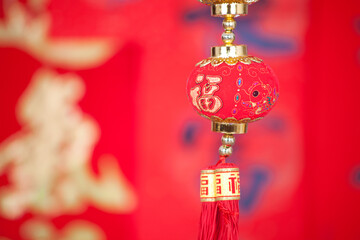 A string of lantern ornaments hung before the red spring couplets.The Chinese character on the lantern means 