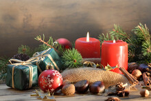 Traditional Christmas Decoration On Wooden Background With Candles And Gifts