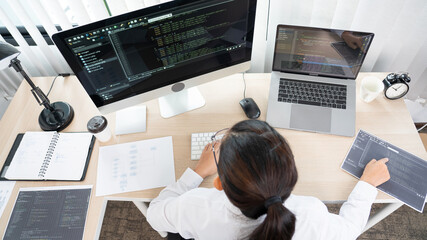 Young Asian woman Programmer Typing code working with computer at table, coding cyberspace and Web Development Concept