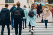 © primipil - Young woman with electric scooter in blue coat at the crosswalk traffic road on city