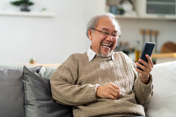 Elderly man use cellphone to make video call to his family