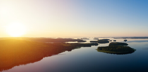 Wall Mural - A calm evening landscape with lake and islands. Panoramic view of sunset over the lake. National park Paijanne. Finland.