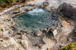 hot geyser with blue water gushing from the rocky ground, Furnas - Sao Miguel