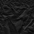 © artistmef - Black vintage and old looking crumpled paper background. Retro cardboard texture. Grunge paper for drawing. Ancient book page. Present wrapping.
