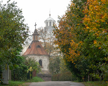 The Street Through The Town Of Sudervė In Lithuania Towards The Bell Tower Of The Holy Trinity Church On A Foggy Autumn Morning. In The Background Is A Dome Of A Classicist Style Church