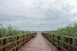 Wooden pier under cloudy sky on Lake Jamno, Mielno, Poland. 