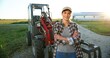 © VAKSMANV - Portrait of beautiful Caucasian young woman in cap standing outdoors a big tractor machine and smiling cheerfully to camera. Pretty happy female farmer worker in field at farm. Agriculture.